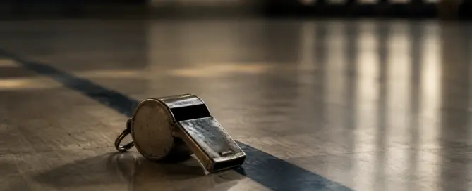 A referee's whistle left on an empty floor, an image of failing institutional trust